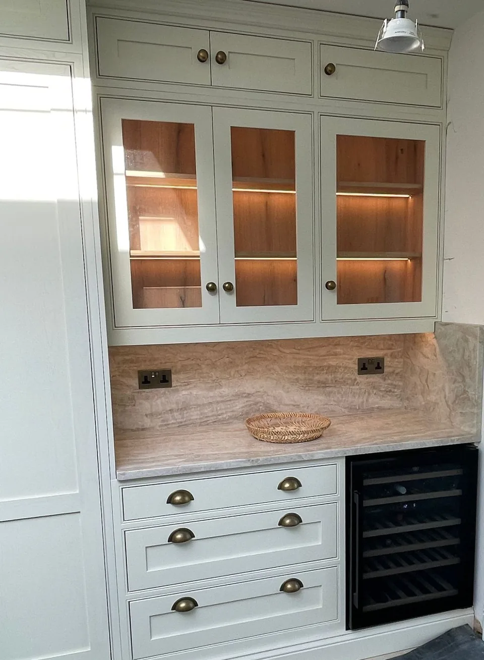 A Wordsworth Range drinks area with glazed cabinets and a wine fridge